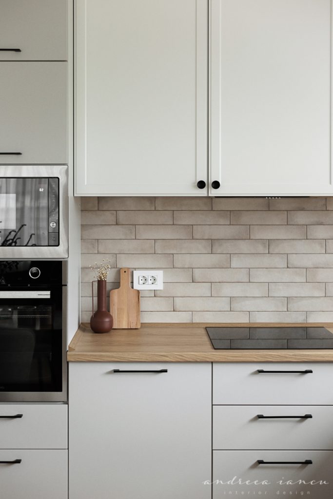 Light grey and white kitchen, with stone metro tiles backsplash.