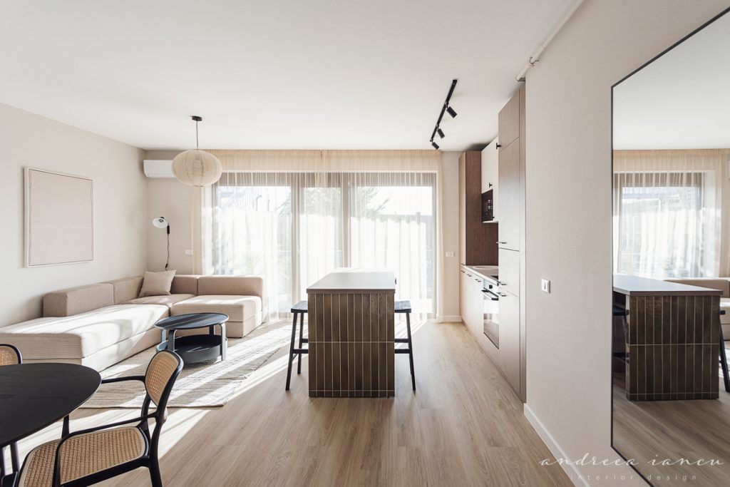 Kitchen and living room view of small apartment interior design with dark wood and moss green tiles.