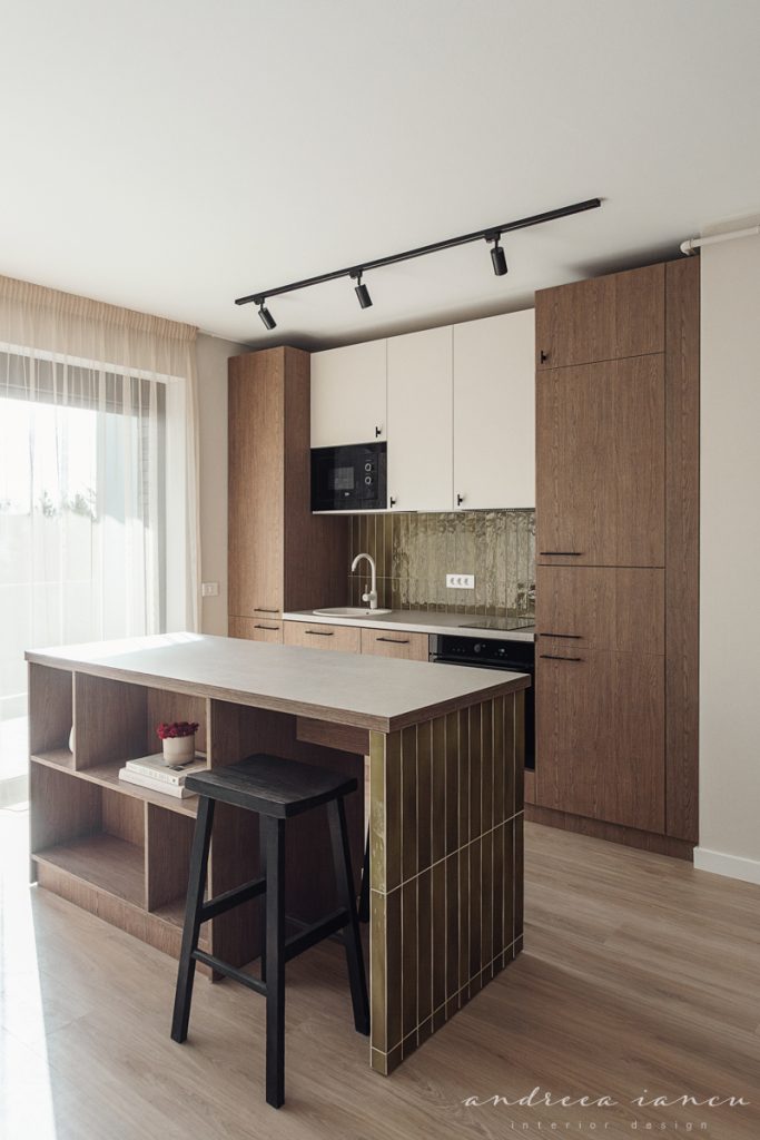 Kitchen view of small apartment interior design with dark wood and moss green tiles.