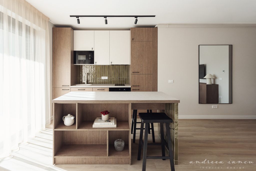 Kitchen view of small apartment interior design with dark wood and moss green tiles.